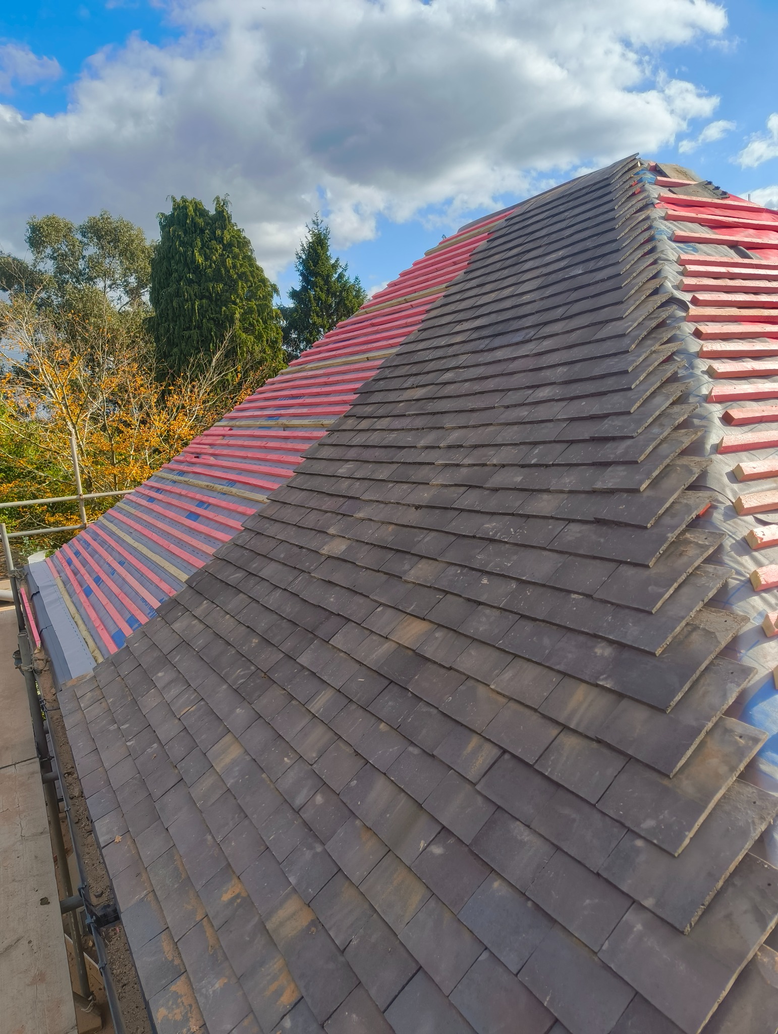 A T Roofing roof replacement in progress with new tiles, battens and membrane
